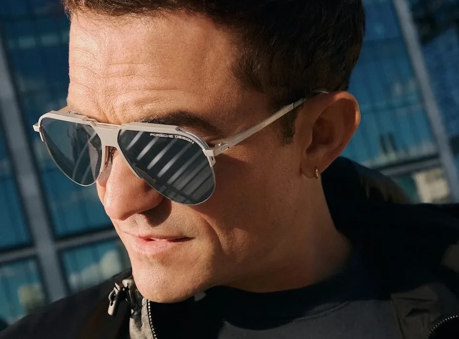 <b>Porsche Design</b> — премиальный люксовый бренд, созданный в 1972 году Фердинандом Александром Порше, дизайнером легендарного спорткара Porsche 911. В индустрии оптики оправы и солнцезащитные очки марки воплощают философию автомобильного бренда: строгую функциональность, гоночную эстетику и технологическое совершенство. <a href="https://shop.porsche.com/us/en-US/p/sunglasses-iconic-tension-P-P8953/4044709552763" target="_blank">Источник фото</a>